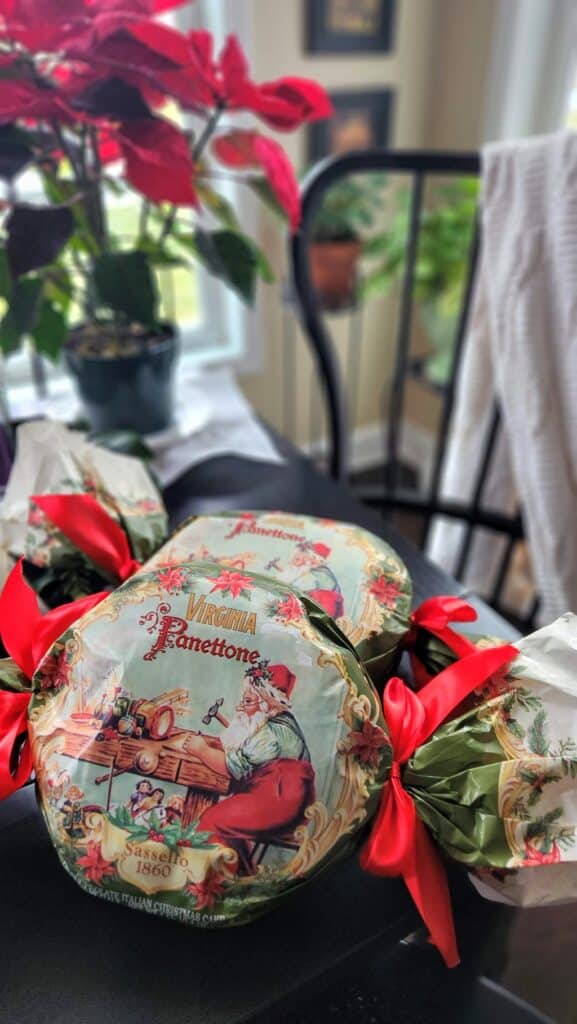 two wrapped panettone loaves with red satin bows