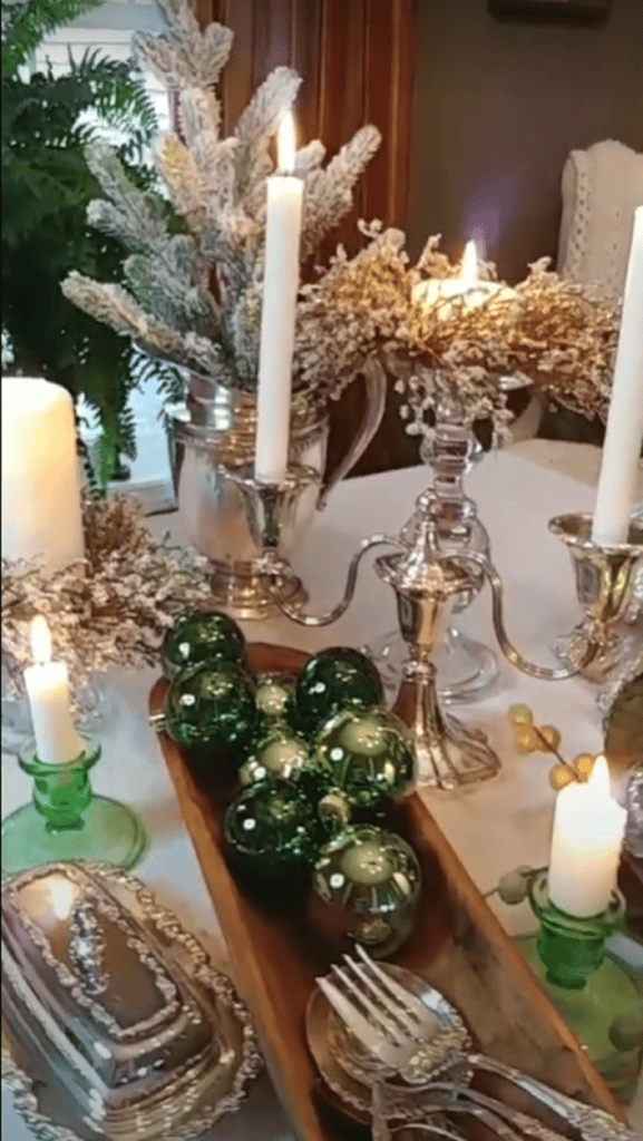 dough bowl with green ornaments in it and silver pieces on the table