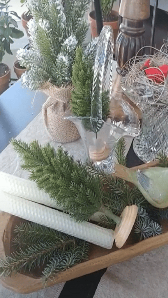 dough bowl with small green christmas trees in it and white beeswax candles