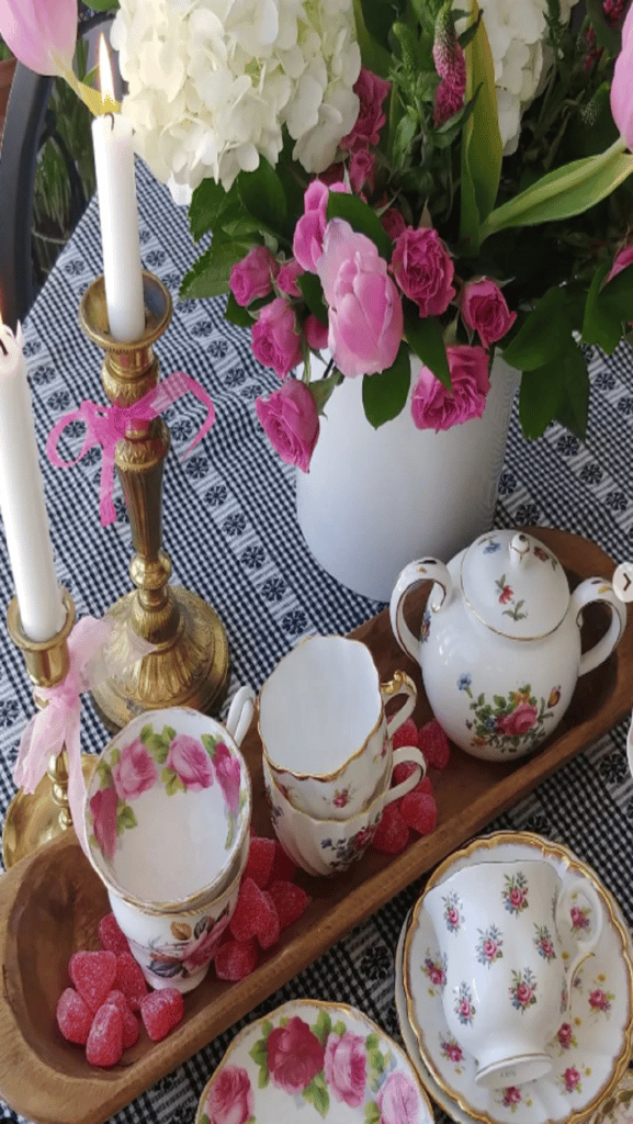 teacups and pink flowers on table in a dough bowl