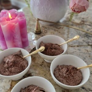 chocolate mousse in 4 cups with candle on a counter