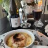 French onion soup in white crock on top of table