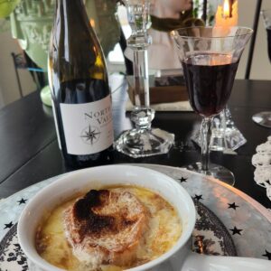 French onion soup in white crock on top of table