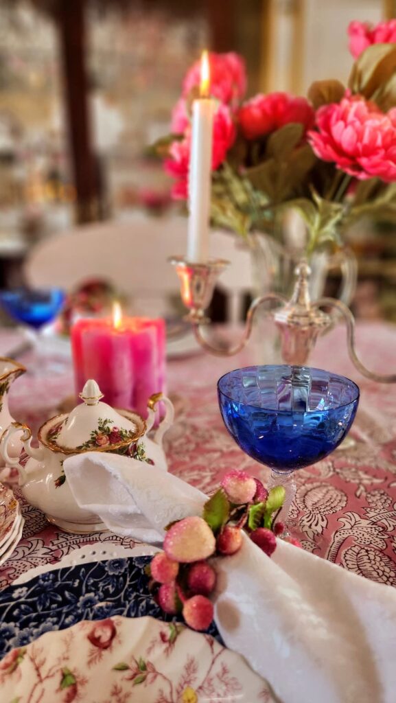 blue goblet on table with pink candle