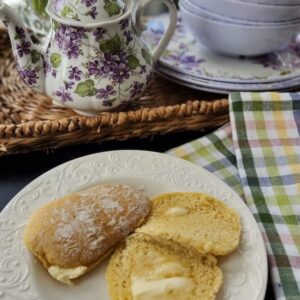 buttermilk scones on plate on table with melted butter on them
