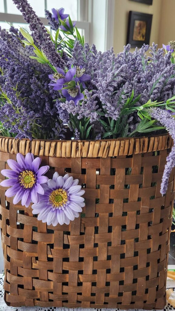 wicker basket with two faux flowers on the face of basket