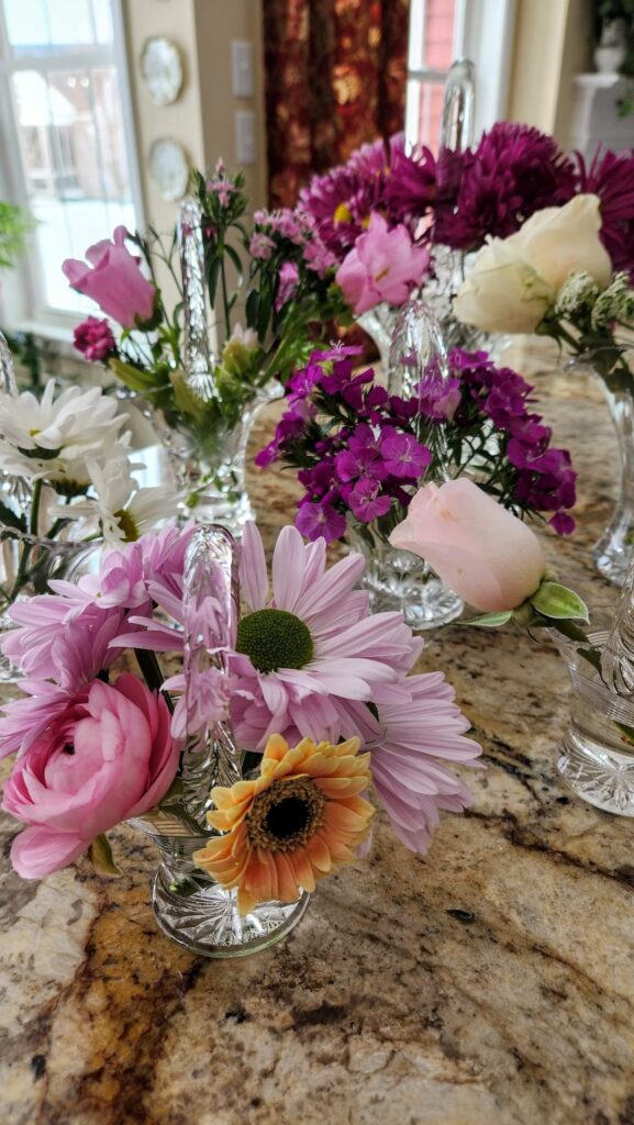 different flowers in crystal basket on table