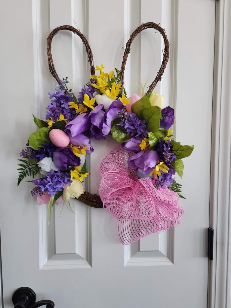 bunny wreath with purple and pink flowers hanging a door