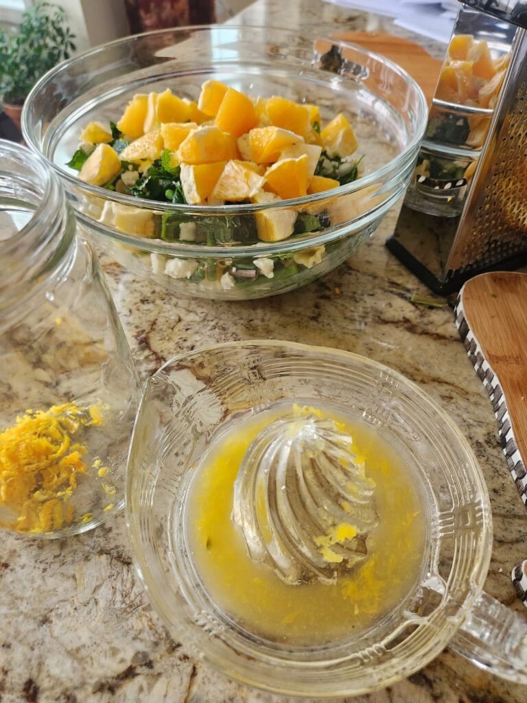 orange being juiced in glass juicer