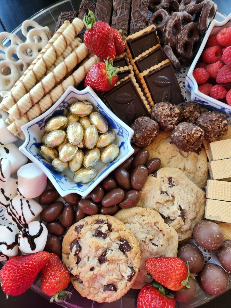 items on charcuterie board cookies, candies, strawberries