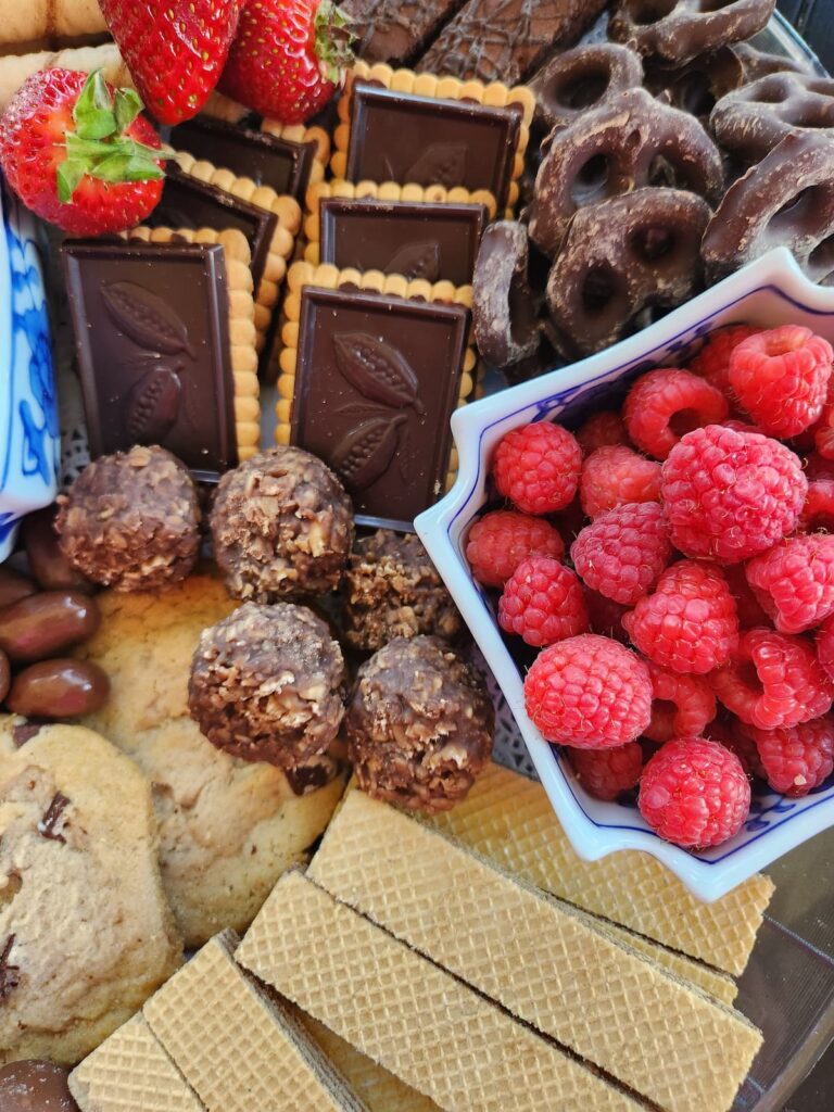 chocolate cookies and candy with raspberries on platter