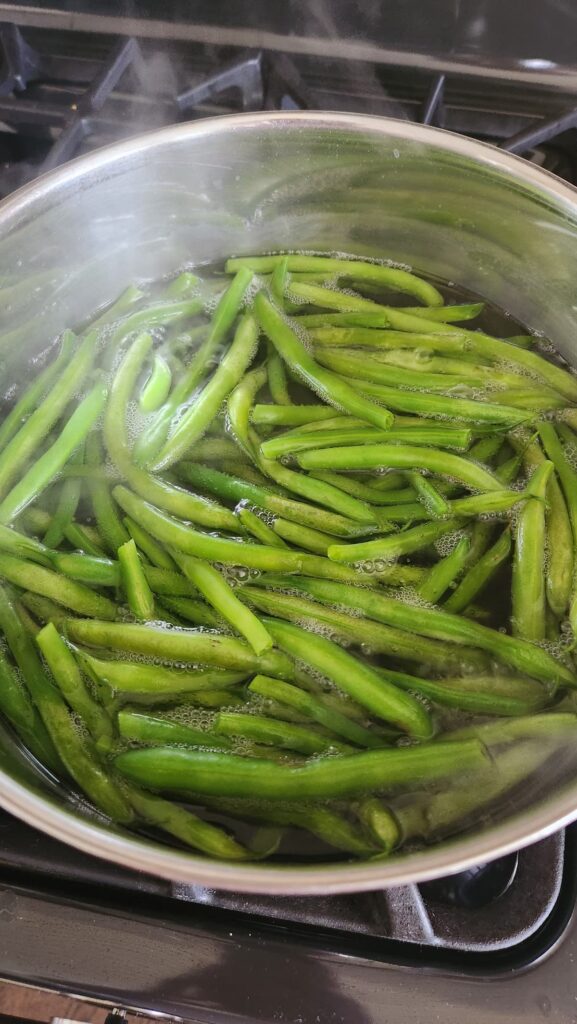 overhead view of green beans in pot of water