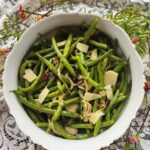 overhead of vegetarian green beans with shaved cheese and cranberries