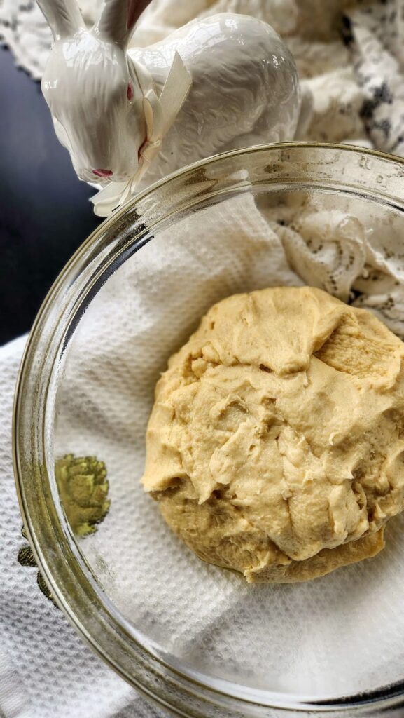 overhead view of easter bread dough in glass bowl before the dough rises