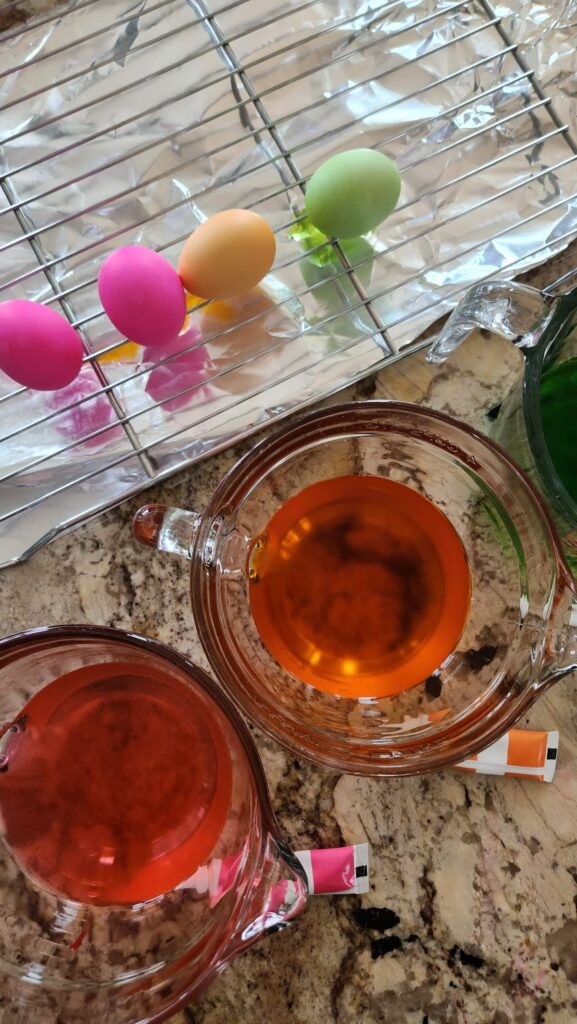 overhead view of colored eggs being dried on wire rack