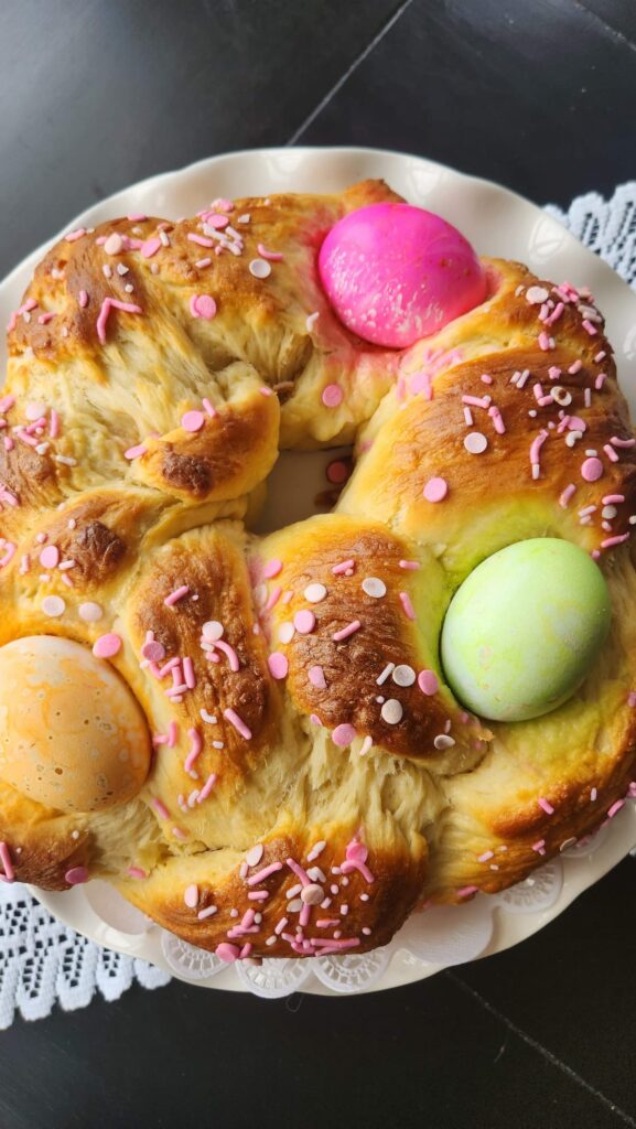 overhead of easter braided easter bread with colored eggs in it