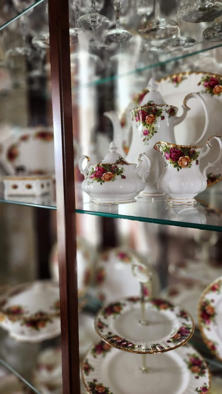 teapot, creamer and sugar on glass shelf in dining room hutch