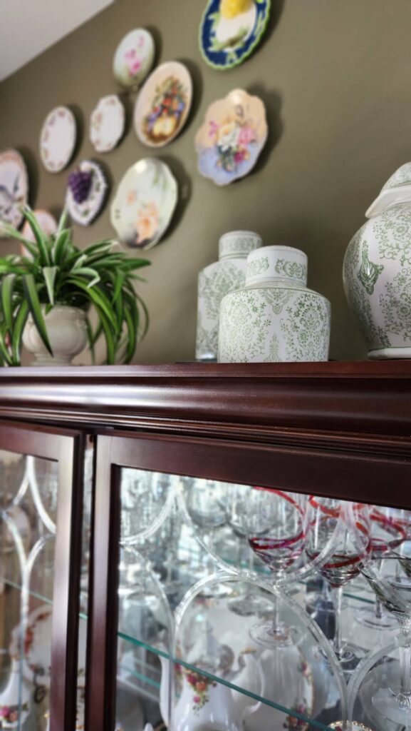 ginger jars and greenery on top of dining room hutch