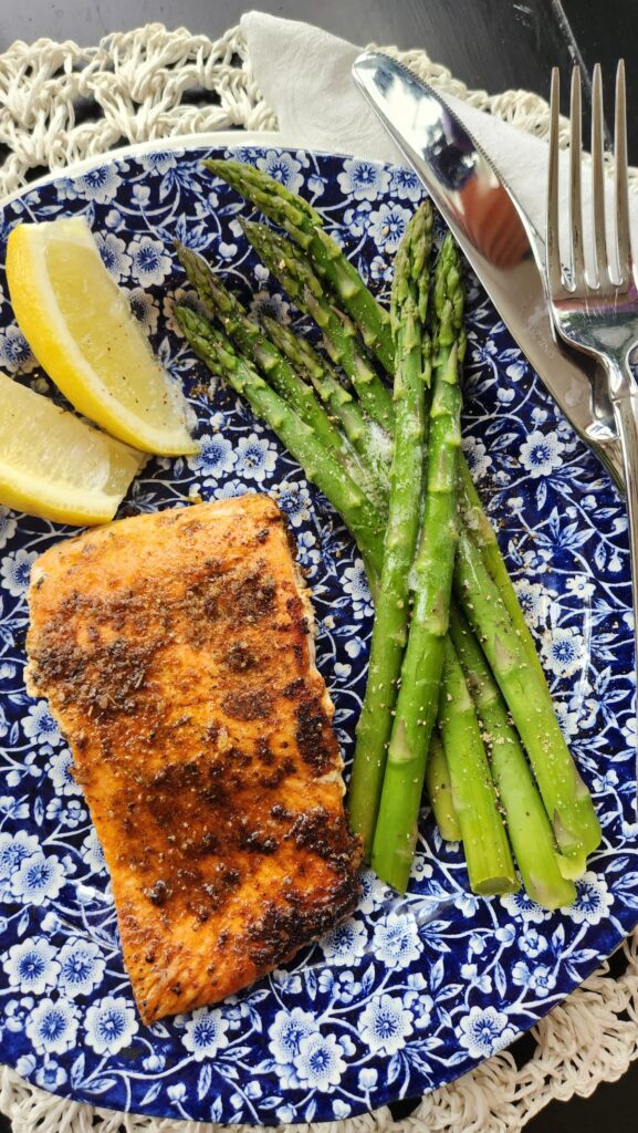 overhead view of blackened salmon dinner with asparagus and lemon slices on plate