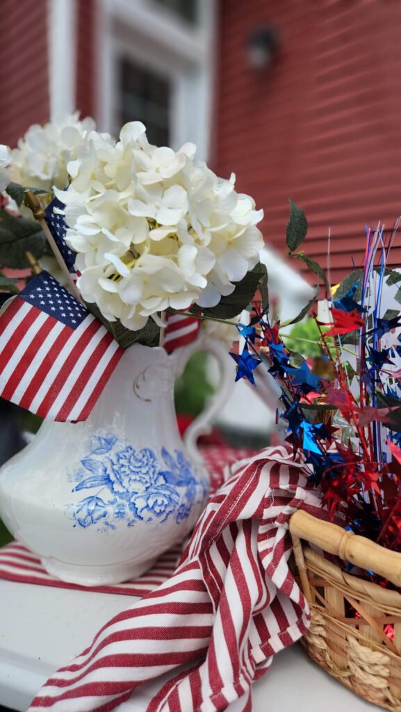 vintage blue and white pitcher filled with flags and white flowers