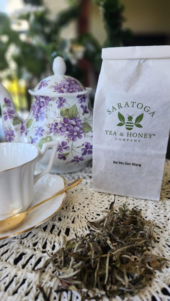 loose tea on table with teapot and white tea cup