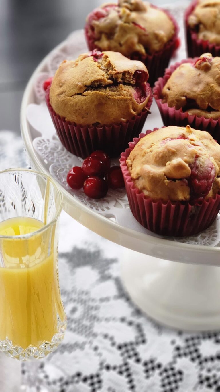 cranberry walnut muffins on a white pedestal dish