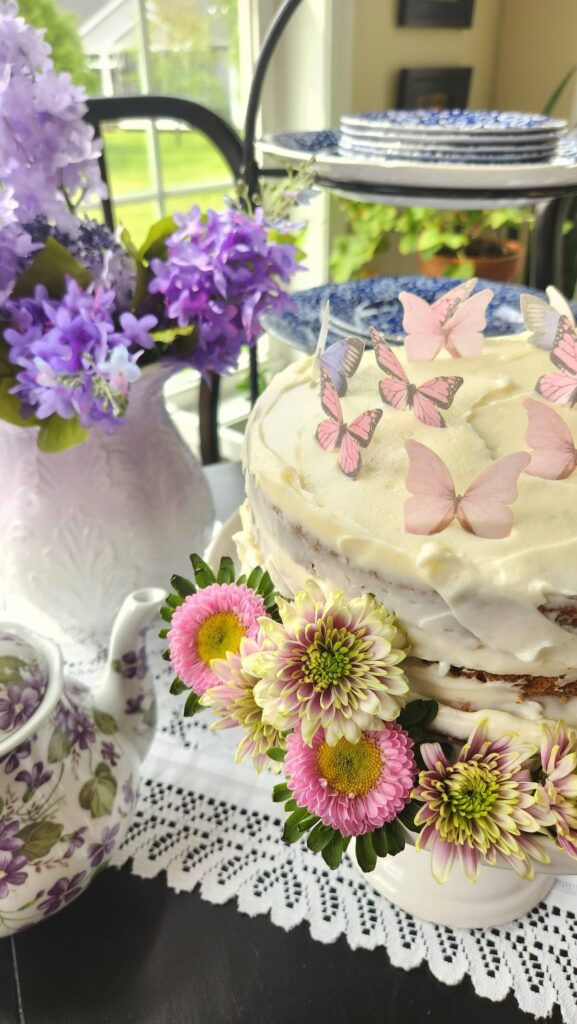 close up of decorated cake with edible butterflies and real flowers around it