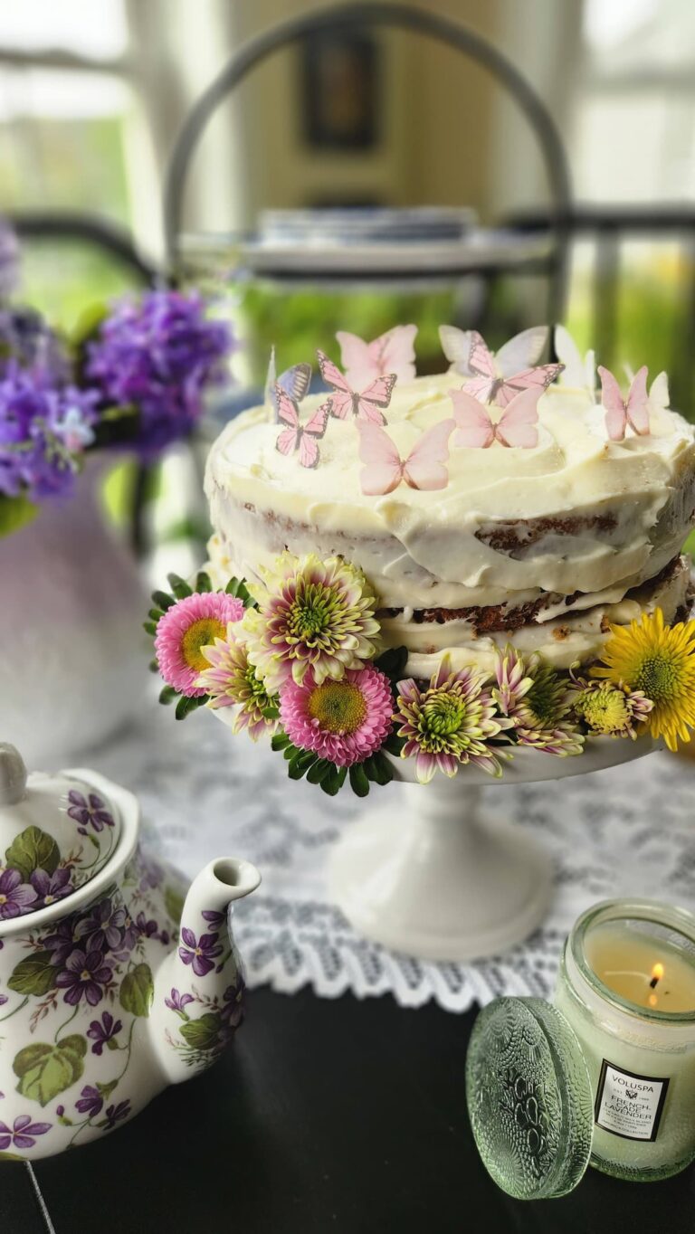 carrot cake decorated with fresh flowers and edible butterflies