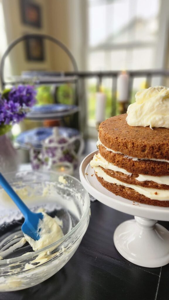 cake on pedestal cake dish with icing being added