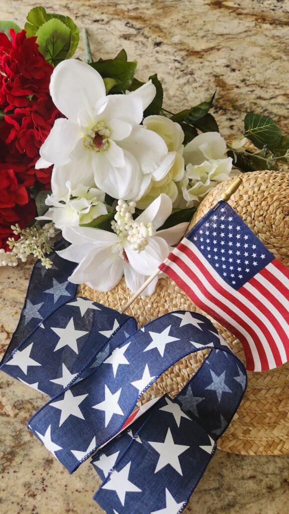 blue star ribbon, straw hat and red and white flowers fo decorate a hat diy door wreath