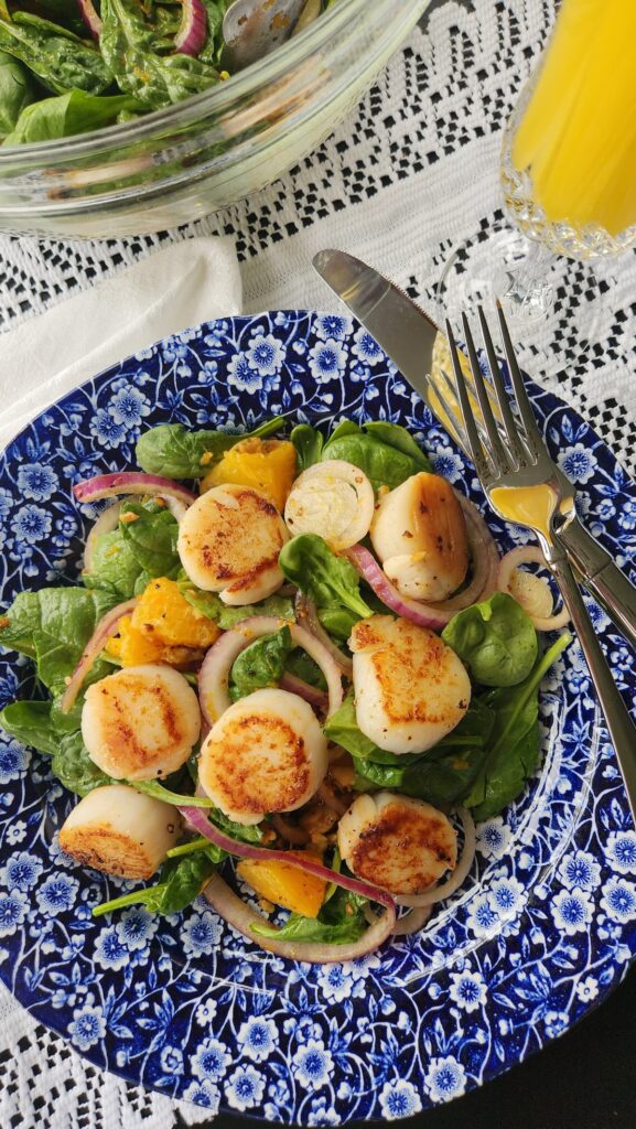overhead photo of orange scallop salad with red onions
