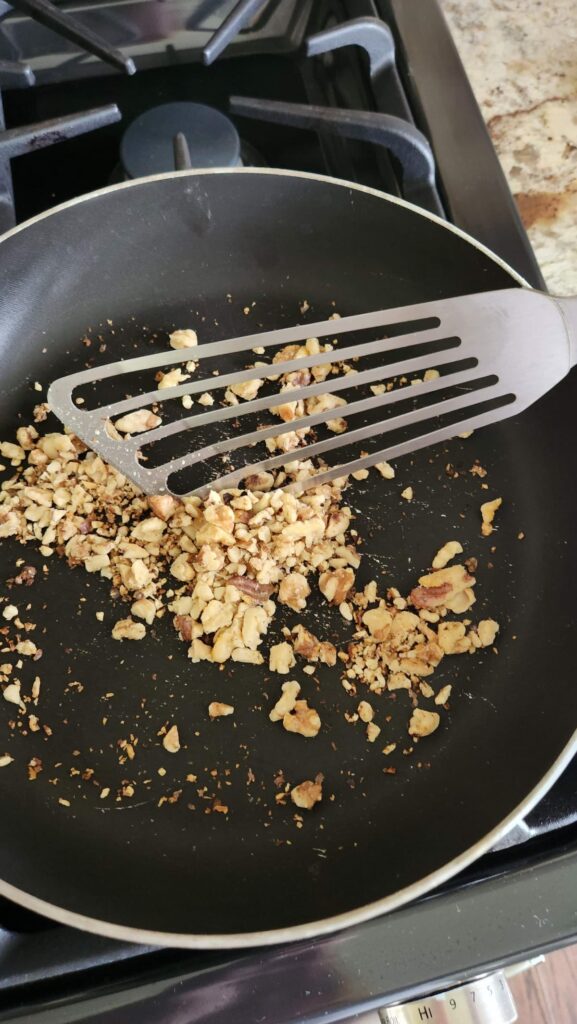 walnuts in non stick pan being toasted