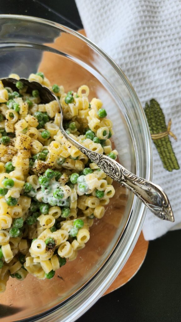 pasta and pea pasta salad in glass bowl overhead photo