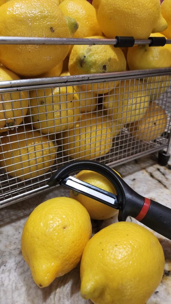 wire bin of lemons with peeler on counter