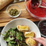 Cranberry Spinach salad with brie toast in white dish