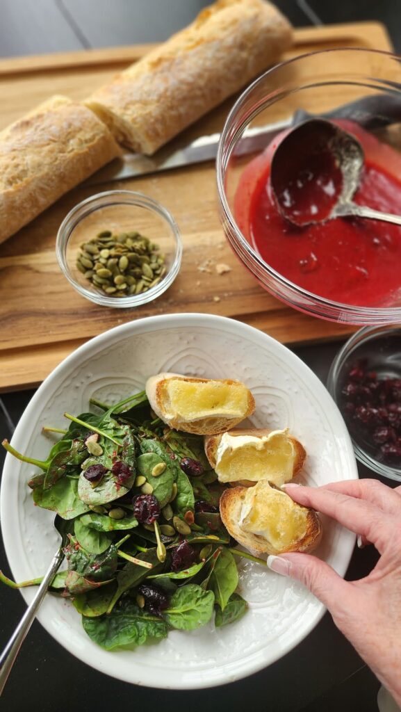 Cranberry Spinach salad with brie toast in white dish