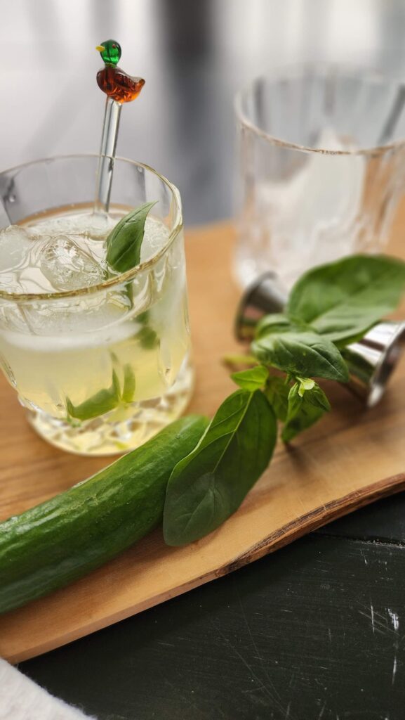 cucumber basil vodka smash in glass  on a table