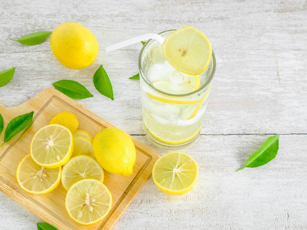 overhead of lemons on table with limoncello in glass