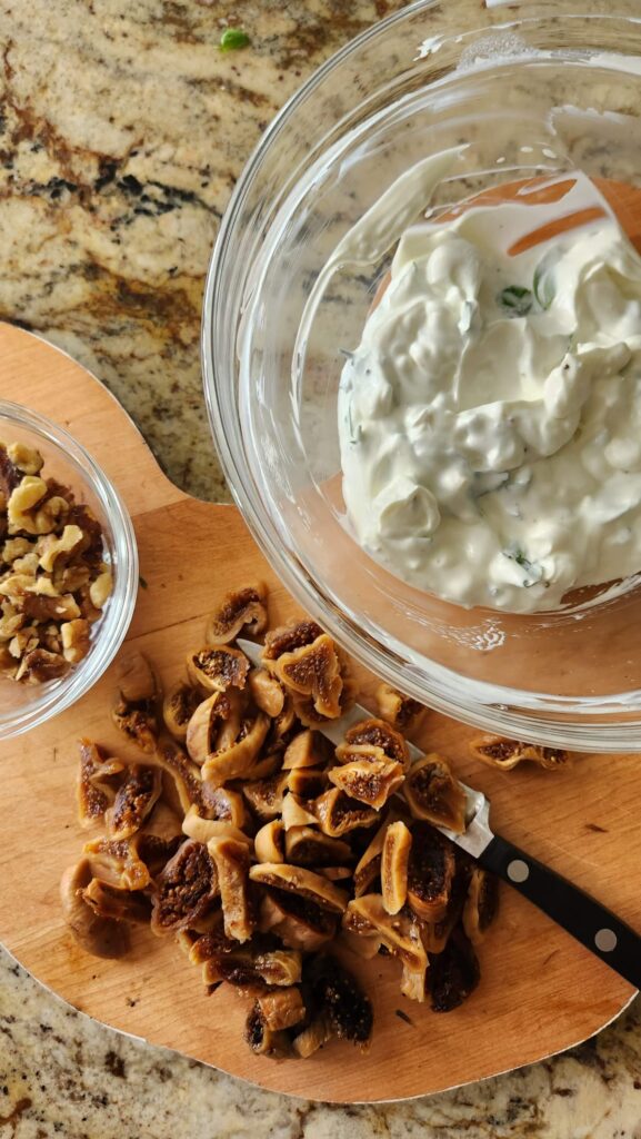 overhead view of boiled figs sliced thinly and goat cheese mixture in bowl