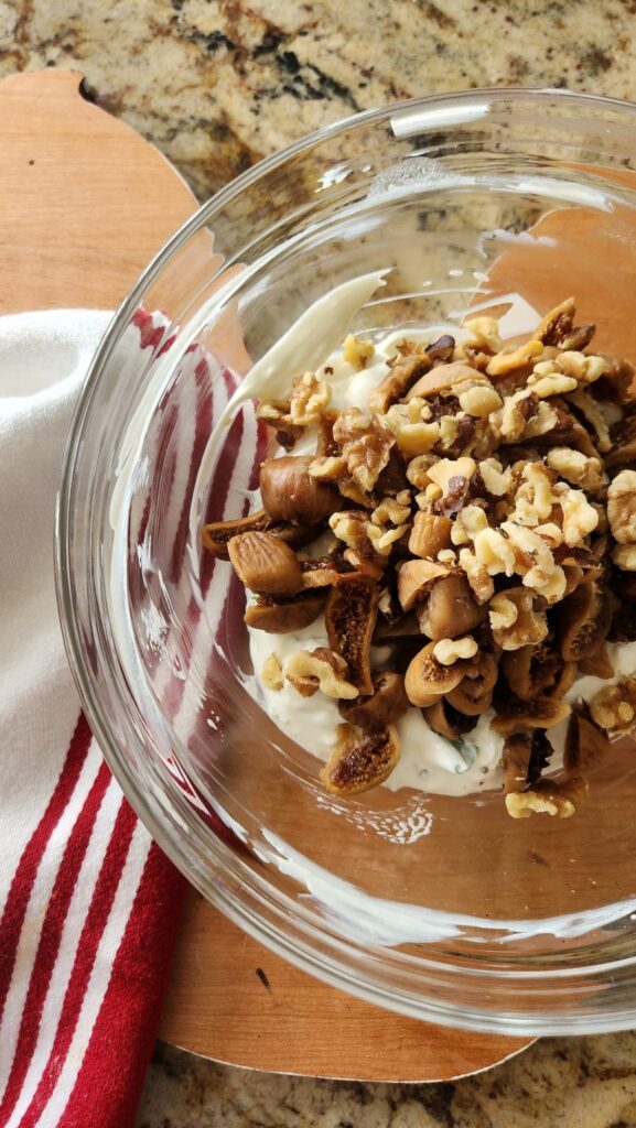 glass bowl with goat cheese, figs and sour cream being mixed