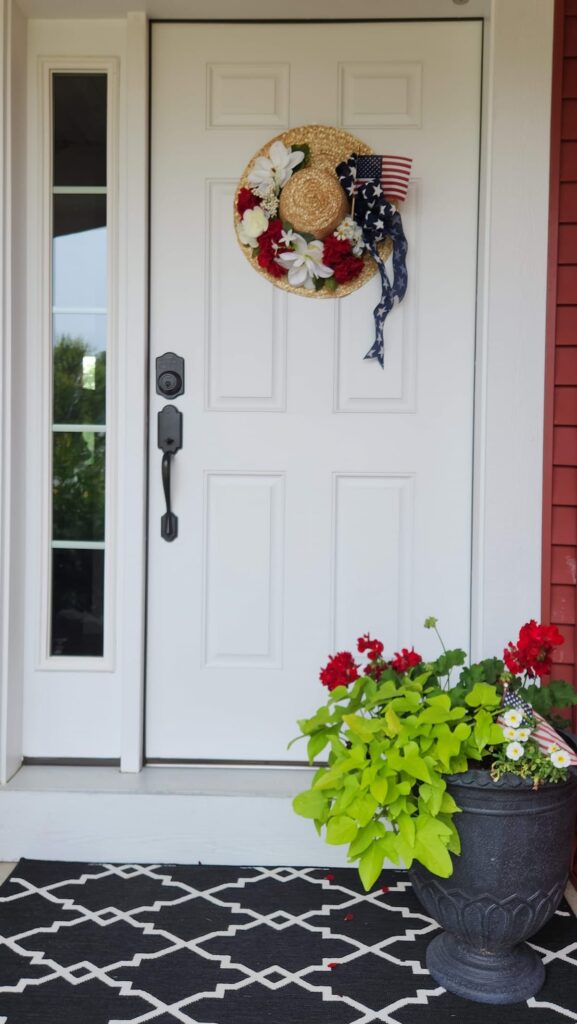 front door with red white and blue hat wreath on door