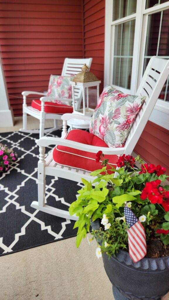 white rocking chairs with red cushion and flowered pillows