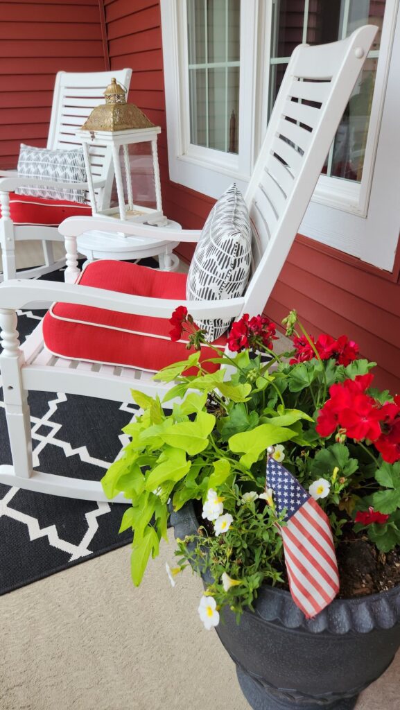 white rocking chair with red cushions and black and white pillows
