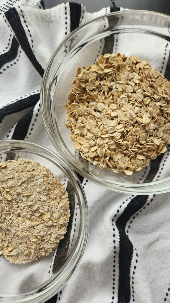 two glass mixing bowls side by side with oatmeal and fine oatmeal ground up