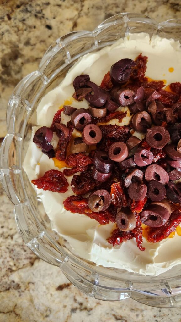 overhead view of goat cheese spread with olives on top