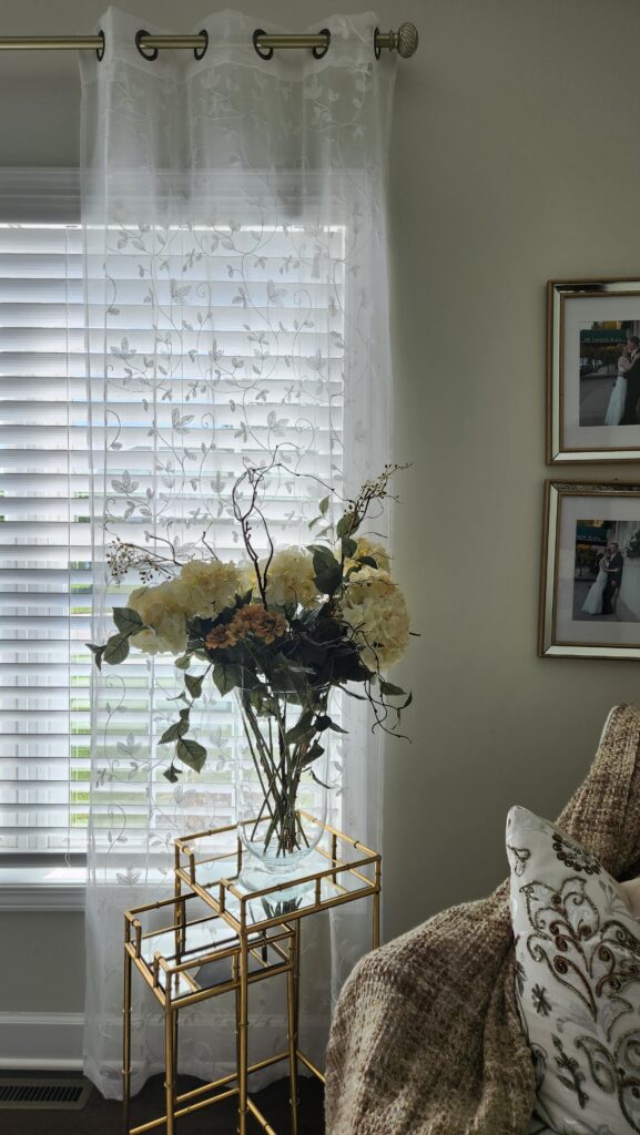 sheer curtains on window with flowers in front of window