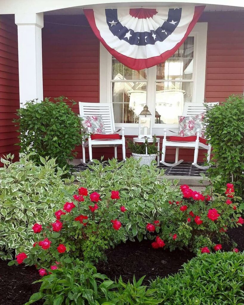 front porch with flag bunting and white rocking chairs