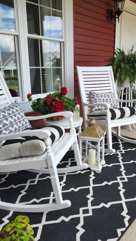 white rocking chairs on front porch with black and white cushions