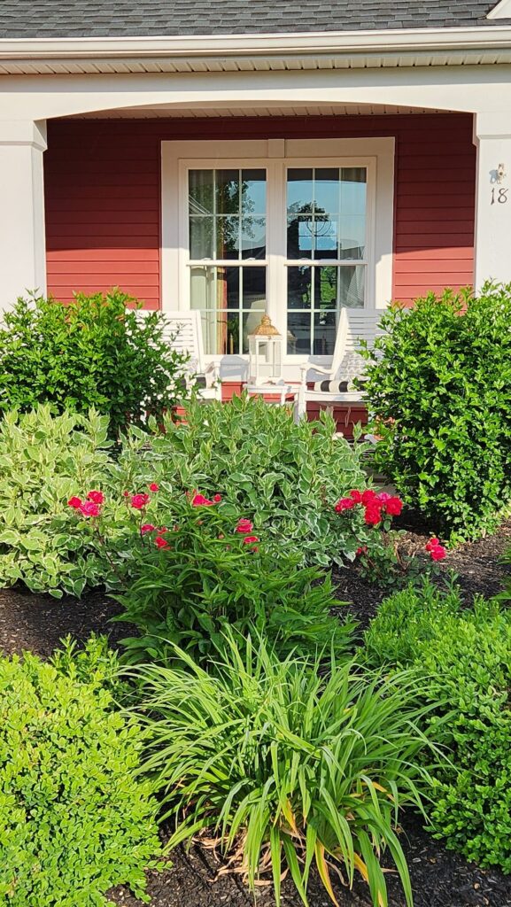 front porch view with garden plants and roses in front of porch