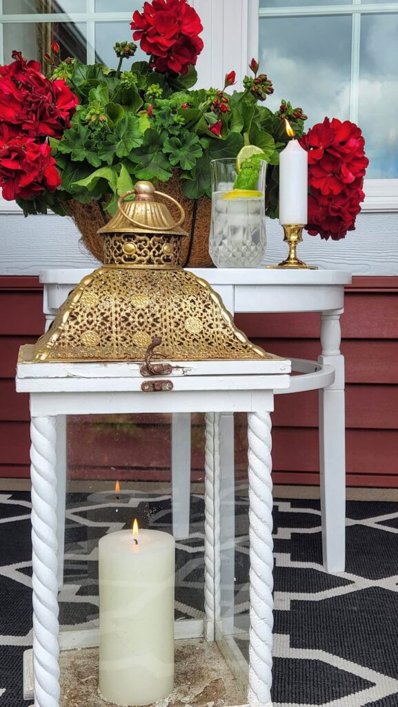 White lantern with gold top on porch table